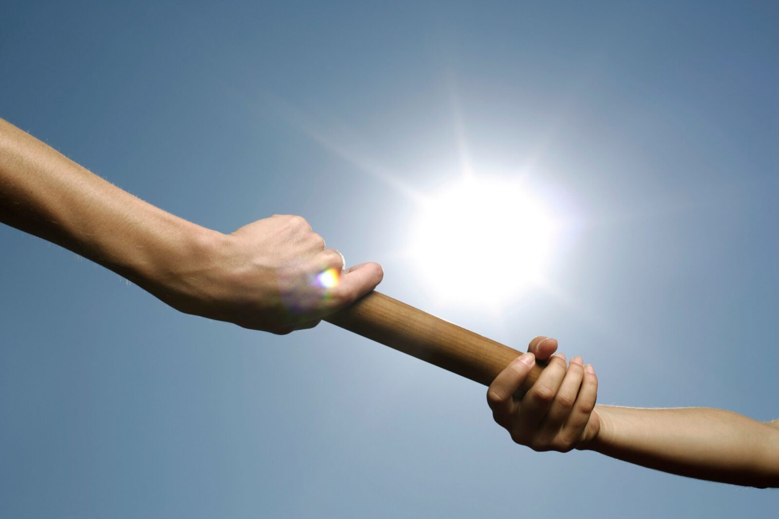 close-up-hand-set-baton-from-hand-hand-sky-background-business-concept-teamwork-team-builder